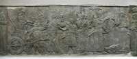019 - Nimrud (± 860) Assurbanipal, descendu de son char, passe en revue les prisonniers - Un soldat assyrien probablement récompensé, lui embrasse les pieds